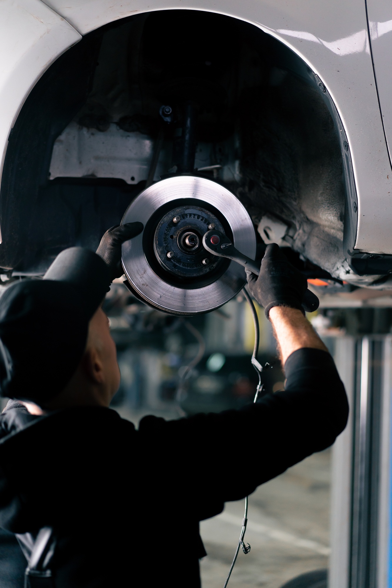 in a service station in the pavilion an auto mechanic tightens the bolts on car rim