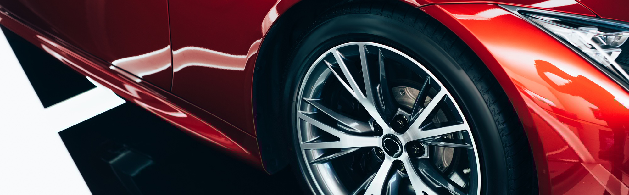 panoramic shot of new shiny red automobile with metallic wheel panoramic shot of new shiny red automobile with metallic wheel